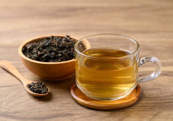 Oolong tea in cup glass with dried Oolong tea leaves on wooden background, Healthy drink